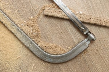 Demir testeresi yerde bir parça testereyle yatıyor.