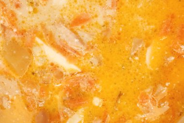 Sağlık portakal suyu yüzeyi. Akşam yemeği. Arka planda yumurta dolu tavuk kremalı çorba. Sarı lezzetli et bulyon dokusu.