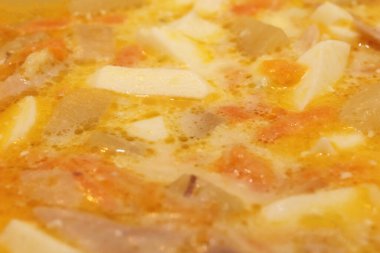 Sağlık portakal suyu yüzeyi. Akşam yemeği. Arka planda yumurta dolu tavuk kremalı çorba. Sarı lezzetli et bulyon dokusu.