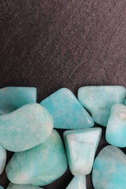 Arka planda siyah taş üzerinde Amazon mücevheri yığını. Yığın mineral çakıl taşı dokusu. Metin için yer.