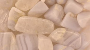 Mavi dantel bir yığın içine dökülür ve saat yönünün tersine döner. Mineral çakıl taşı arkaplanı.