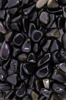 Açık ahşap desenli altın obsidiyan mücevher yığını. Yığın mineral çakıl taşı arkaplanı.