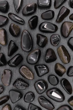 Siyah taş dokusunda altın obsidiyan nadir mücevher. Mineral çakıl taşı arkaplanı.