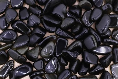 Açık ahşap desenli altın obsidiyan mücevher yığını. Yığın mineral çakıl taşı arkaplanı.