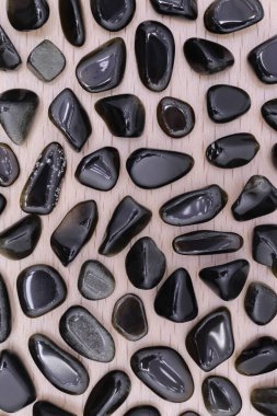 Kahverengi ahşap arka planda altın obsidiyan mücevher dokusu. İnce mineral çakıl taşları yaratıcı.