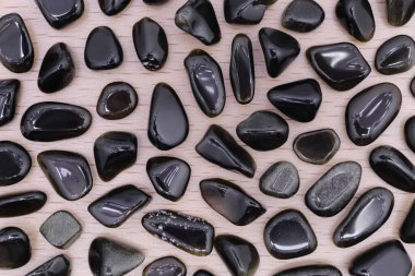 Kahverengi ahşap arka planda altın obsidiyan mücevher dokusu. İnce mineral çakıl taşları yaratıcı.