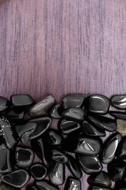 Yarı kahverengi ahşap dokusunda altın obsidiyan nadir mücevher. Yığın mineral çakıl taşı arka planı. Metin için yer.