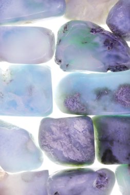 Işık yüzeyindeki Larimar mücevher dokusu. Yığın mineral çakıl taşları yaratıcı.