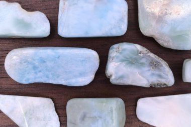 Larimar nadide mücevheri yarım kahverengi ahşap dokusunda. Yığın mineral çakıl taşı arka planı. Metin için yer.