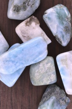 Kahverengi ahşap desenli Larimar mücevheri. Yığın mineral çakıl taşı arkaplanı.