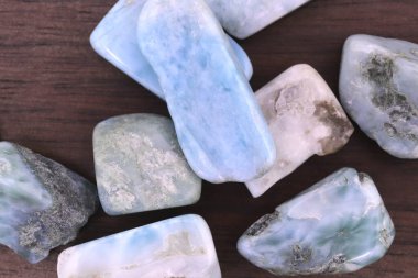 Kahverengi ahşap desenli Larimar mücevheri. Yığın mineral çakıl taşı arkaplanı.