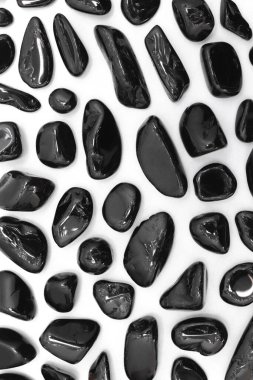 İzole edilmiş beyaz arka planda nadir bulunan siyah turmalin mücevher dokusu. Nadir bulunan çakıl taşları doğa arkaplanı.
