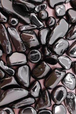 Kahverengi ahşap arka planda siyah turmalin mücevher dokusu. Yığın mineral çakıl taşları doğa arka planı.