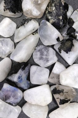 Siyah taş arka planda ay taşı yığını mücevher dokusu. Yığın mineral çakıl taşları doğa arka planı.