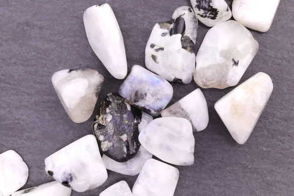 Ay taşı siyah taş dokusunda rastgele bir mücevher yığını. Yığın mineral çakıl taşı arkaplanı.