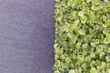 Yarım siyah taş arka planda Olivine hurda mücevher dokusu. Metin için yer.