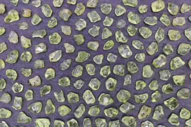 Siyah taş dokusunda Olivin nadir bulunan bir mücevher. Mineral çakıl taşı arkaplanı.