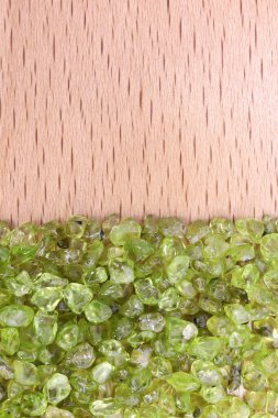 Yarım açık renkli ahşap desenli Olivine hurdalığı mücevheri. Yığın mineral çakıl taşı arka planı. Metin için yer.