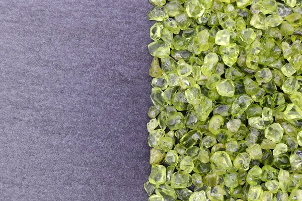 Yarım siyah taş arka planda Olivine hurda mücevher dokusu. Metin için yer.