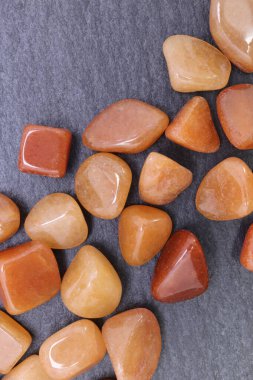 Kırmızı Aventurine mücevheri siyah taş arka planda üst üste yığılır