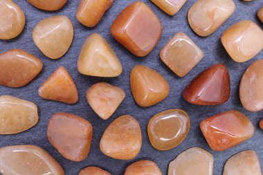 Siyah taş dokusunda nadir bulunan Red Aventurine mücevheri. Mineral çakıl taşı arkaplanı.