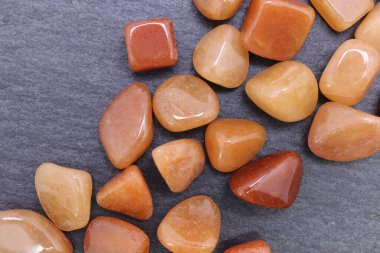 Kırmızı Aventurine mücevheri siyah taş arka planda üst üste yığılır