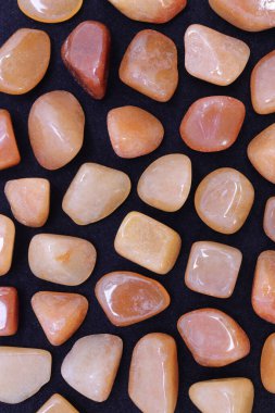 Kırmızı Aventurine, siyah arka planda nadir bulunan mücevher dokusu. Mineral çakıl taşları arkaplan.