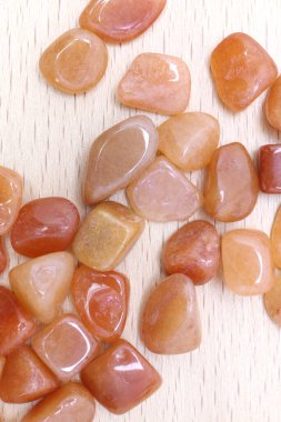 Red Aventurine mücevheri parlak ahşap arka planda üst üste yığılır.