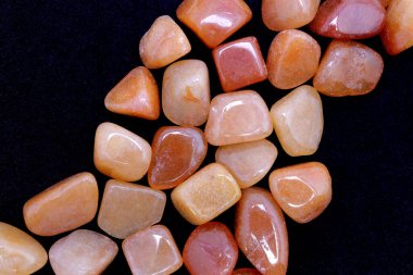 Kırmızı Aventurine mücevheri siyah arkaplanda birikiyor.