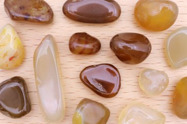 Sarı Agate mücevher taşları. Hafif ahşap arka planda nadir bir doku.