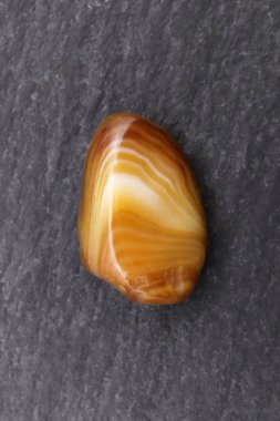 Siyah taş zemin üzerinde sarı Agate mücevher taşı dokusu. Makro yakın çekim.