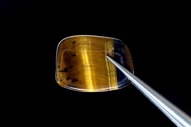 Siyah arka planda cımbızla kaplan gözü mücevheri dokusu. Makro yakın çekim.