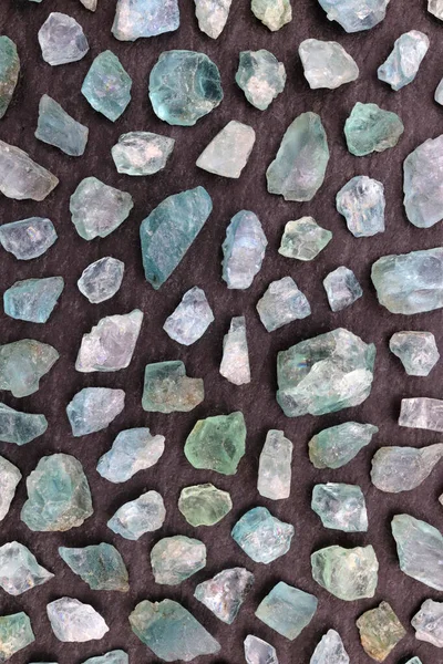 Apatite rare jewel stones filled texture on black stone background.