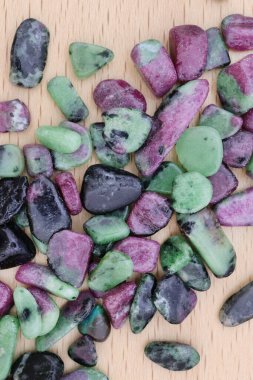 Yakut zümrüt mücevher taşları parlak ahşap arka planda dokuları üst üste yığar.