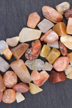 Kırmızı ipek yeşim taşı taşları siyah taş arka planda üst üste yığılır.