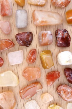 Kırmızı ipek yeşim taşı. Hafif ahşap arka planda bulunan değerli taşlar. Metin için yer.