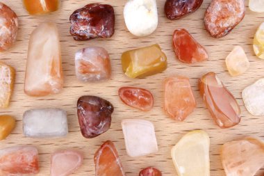 Kırmızı ipek yeşim taşı. Hafif ahşap arka planda bulunan değerli taşlar. Metin için yer.