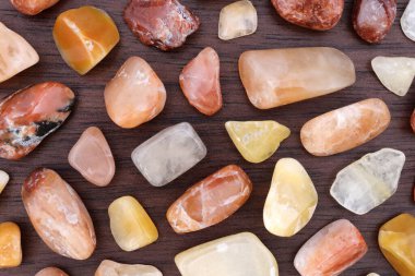 Kahverengi ahşap arka planda kırmızı ipek taşlı nadir mücevher dokusu. Metin için yer.