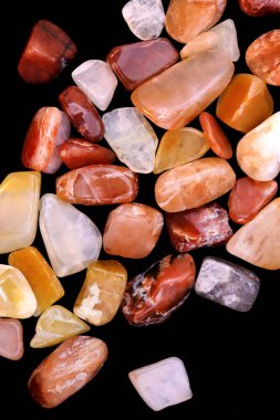 Kırmızı ipek taşlı yeşim taşları siyah arkaplandaki dokuları üst üste yığıyor.