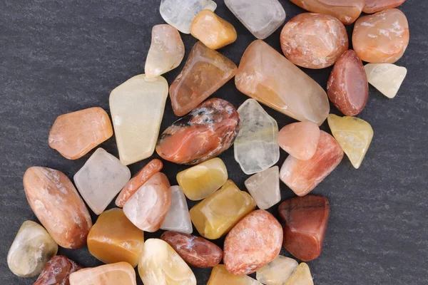 Kırmızı ipek yeşim taşı taşları siyah taş arka planda üst üste yığılır.