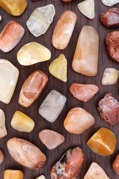 Kahverengi ahşap arka planda kırmızı ipek taşlı nadir mücevher dokusu. Metin için yer.