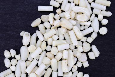 Beyaz mercan siyah taş dokusuna mücevher yığar. Yığın mineral çakıl taşı arkaplanı.