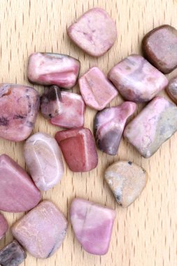 Rodokrosit mücevher taşlarını parlak ahşap arka planda biriktirir.