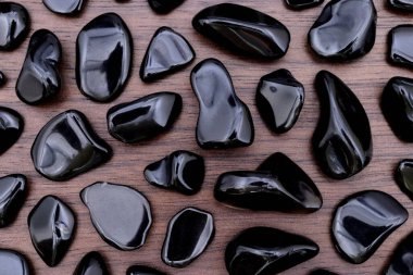 Kahverengi ahşap arka planda Obsidian nadir mücevher taşları dokusu