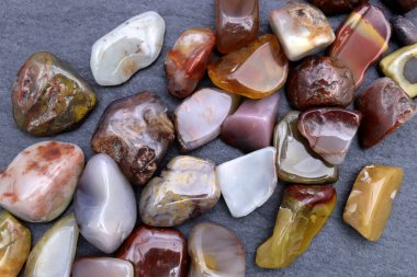 Yanyuan, siyah taş arka planda mücevher taşlarını üst üste yığar.