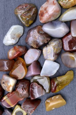 Yanyuan, siyah taş arka planda mücevher taşlarını üst üste yığar.