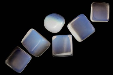 Opal mücevher taşlarını siyah arkaplanda üst üste yığar