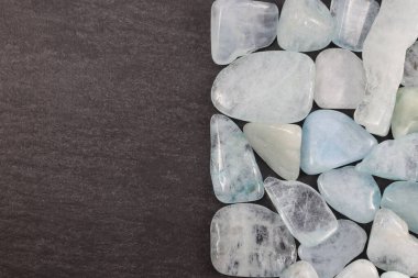 Aquamarine heap jewel stones texture on half black stone background. Place for text.