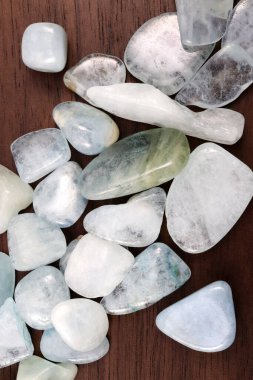 Aquamarine heap up jewel stones texture on brown varnished wood background