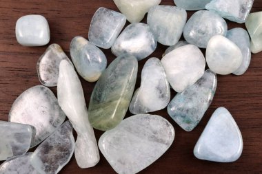 Aquamarine heap up jewel stones texture on brown varnished wood background